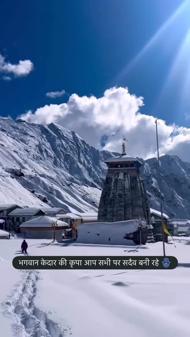 The stone Kedarnath temple below snow-covered Himalayan peaks