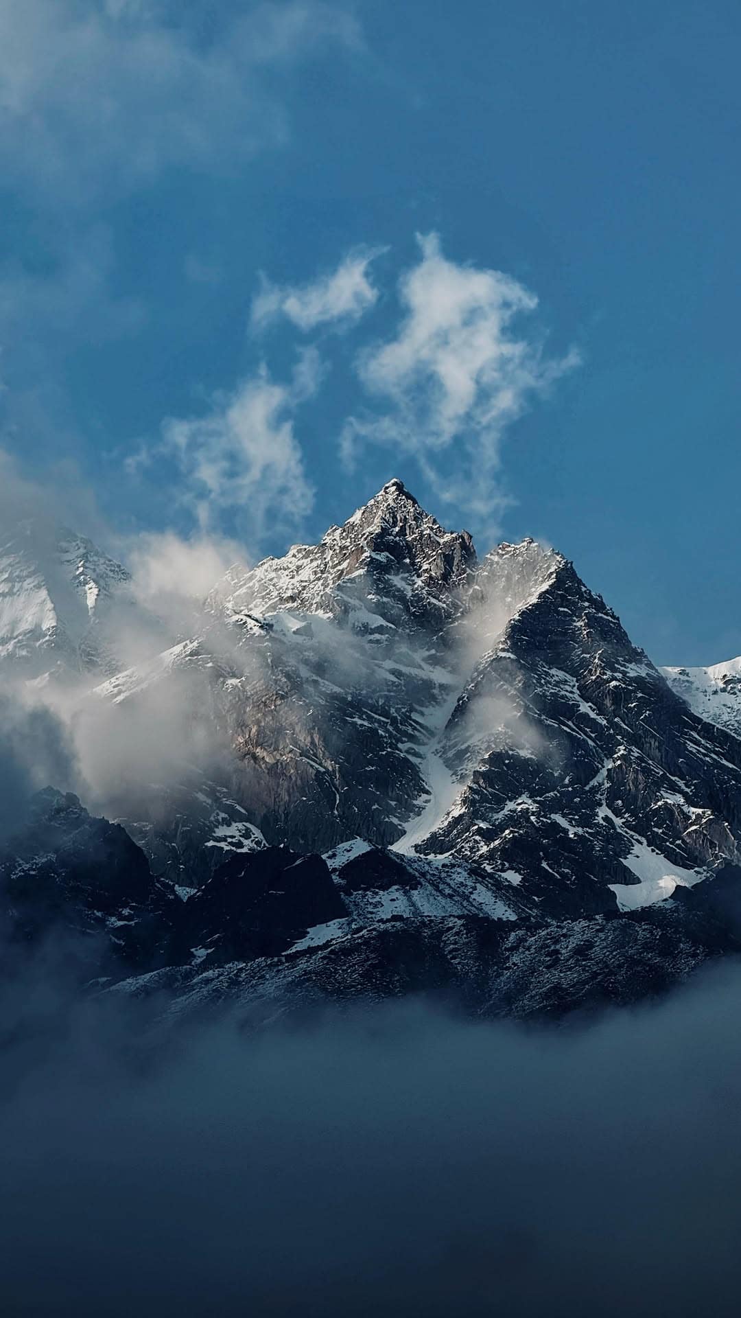 A pilgrim looking up at the Kedarnath temple against snow peaks
